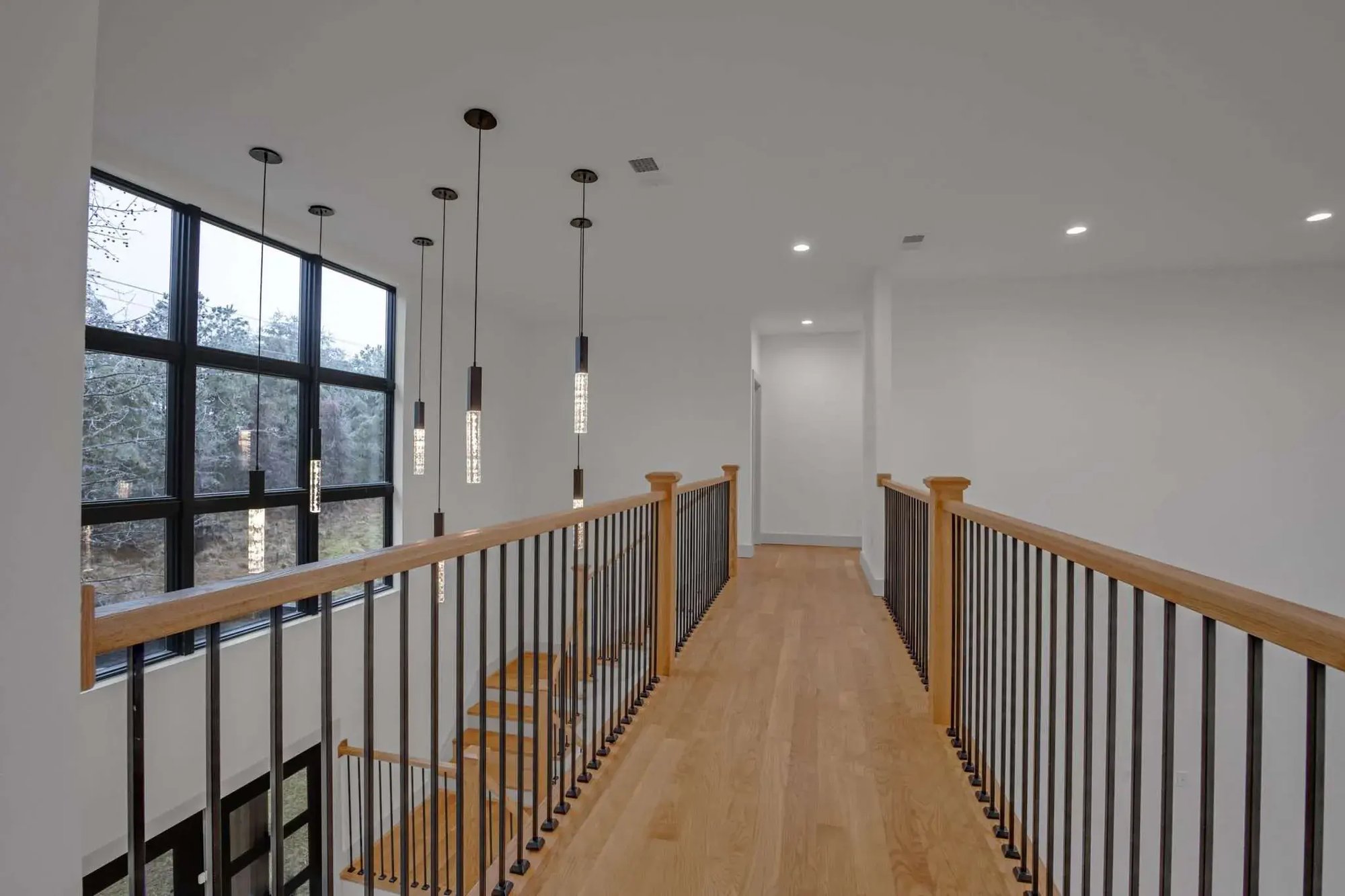 Custom LEED Gold-Certified Smart Home second floor catwalk with view of large windows