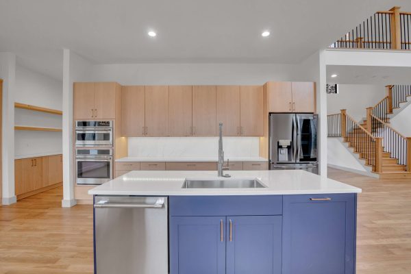 Custom LEED Gold-Certified Smart Home kitchen featuring blue cabinet island and light wood cabinetry