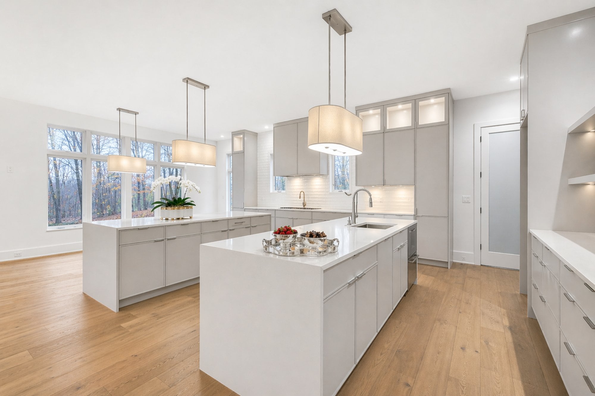 great falls modern tudor kitchen by august homes with large white island custom cabinetry and pendant lighting